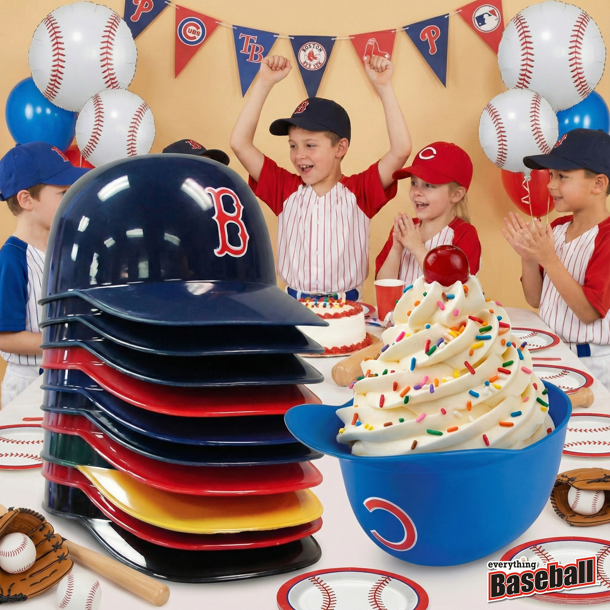 Children in baseball caps with a stack of colorful MLB baseball team ice cream helmets and a cake on a table, featuring baseball-themed decorations.