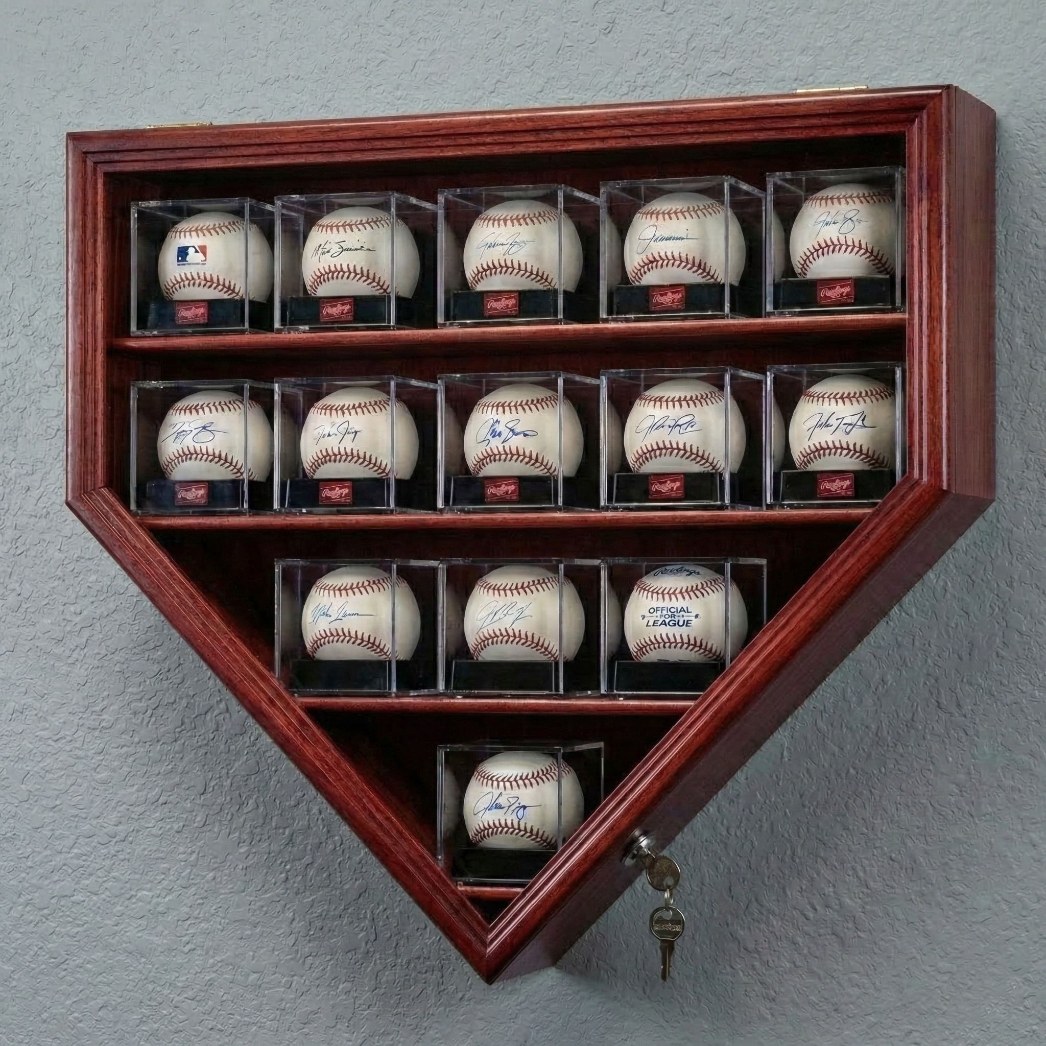 Wooden display case shaped like a home plate with signed baseballs on a gray wall.