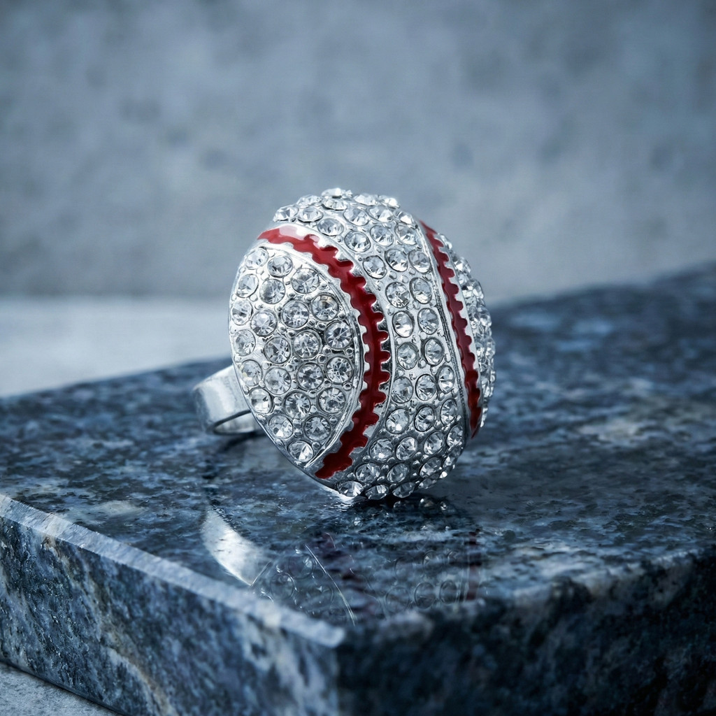 Baseball-shaped ring with crystal embellishments on a dark surface