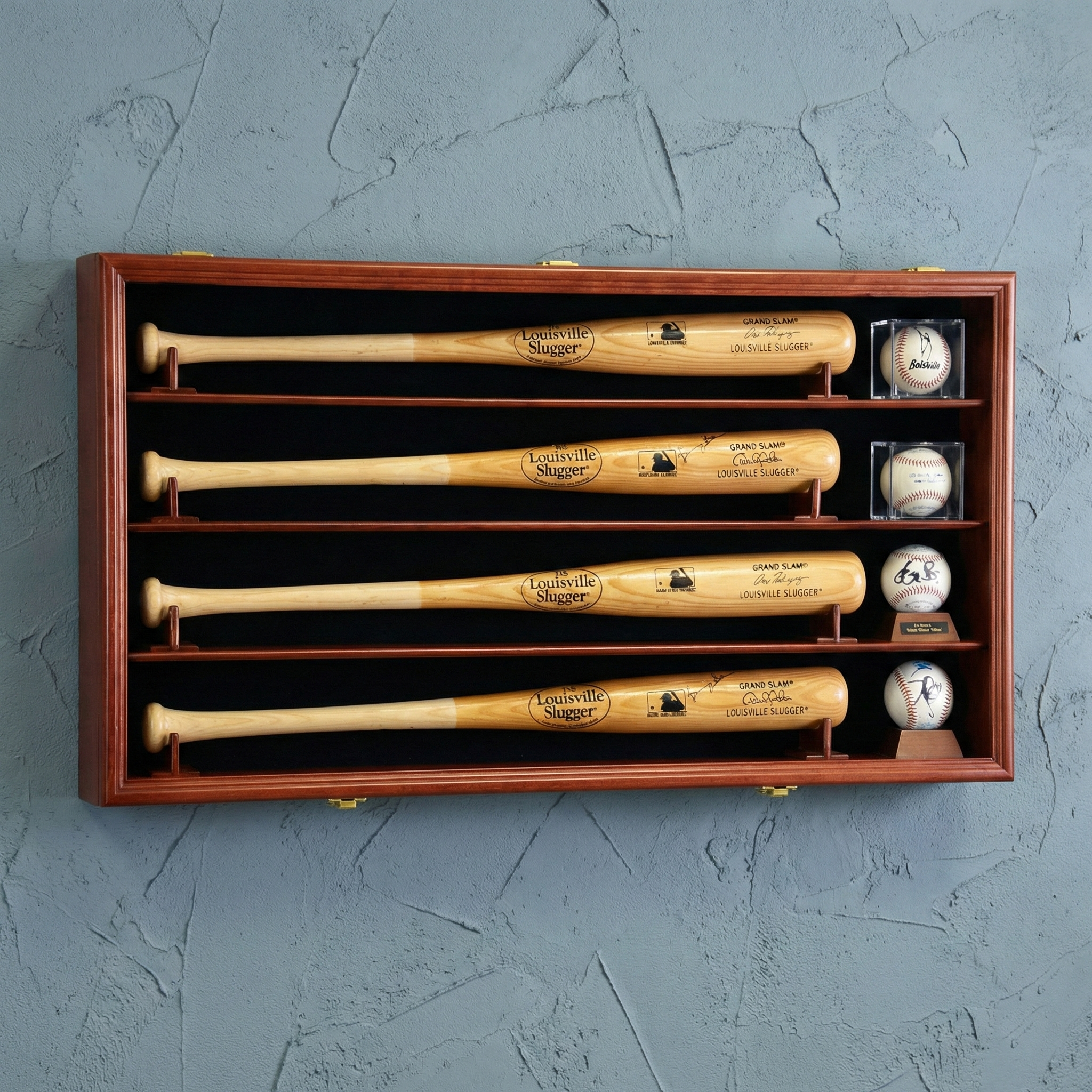 Set of Louisville Slugger baseball bats and balls in a wooden display case on a gray background