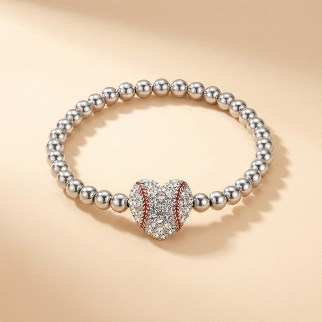 Silver bead stretchy bracelet with a crystal baseball heart-shaped charm on a beige background