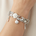 Silver stretch bracelet with baseball charms on a wrist against a neutral background