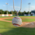Baseball-shaped pendant with crystals on a silver chain against a baseball field background