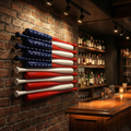 American flag made of red, white, and blue baseball bats on a brick wall in a bar setting.