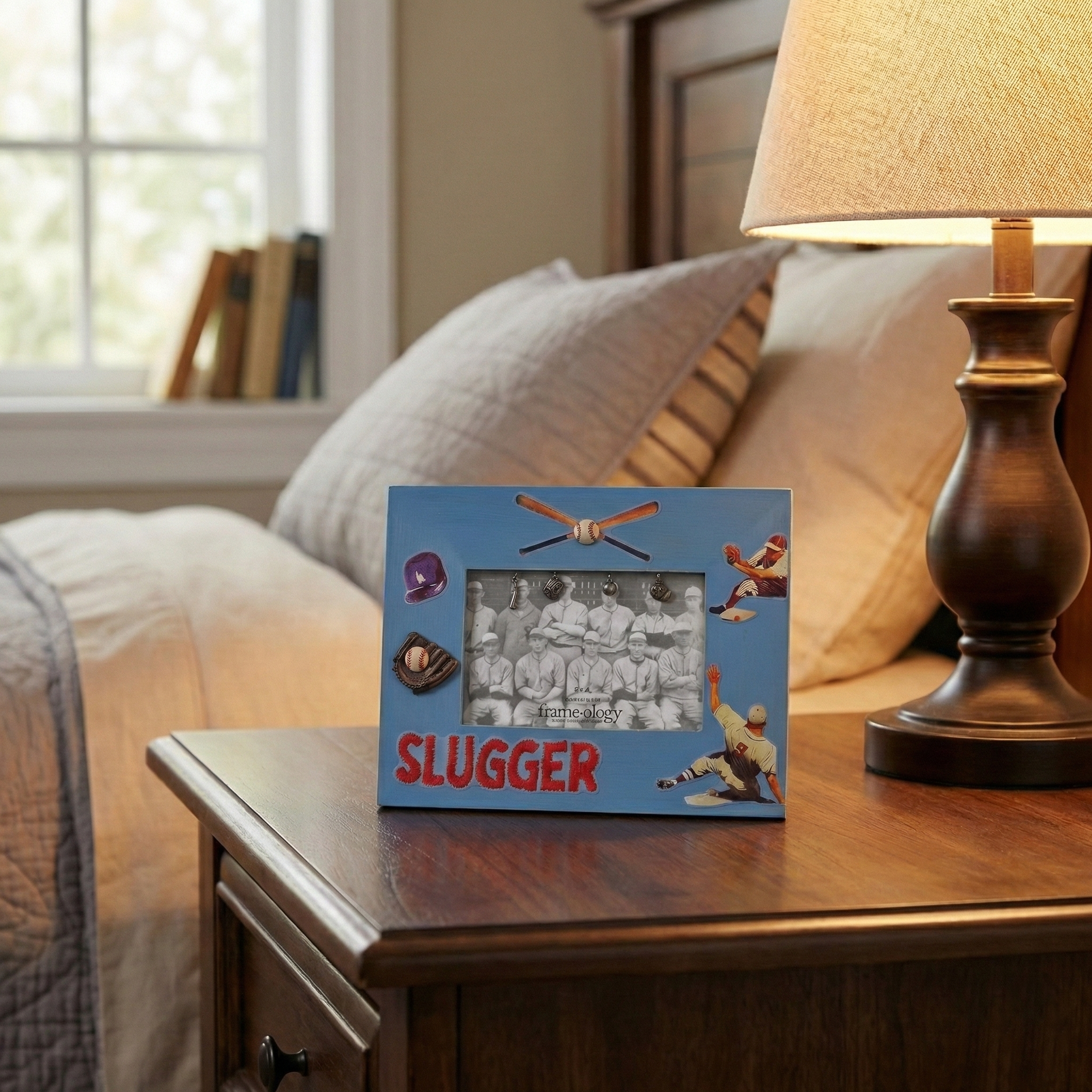 Baseball photo frame with 'SLUGGER' on a nightstand next to a lamp and pillows.