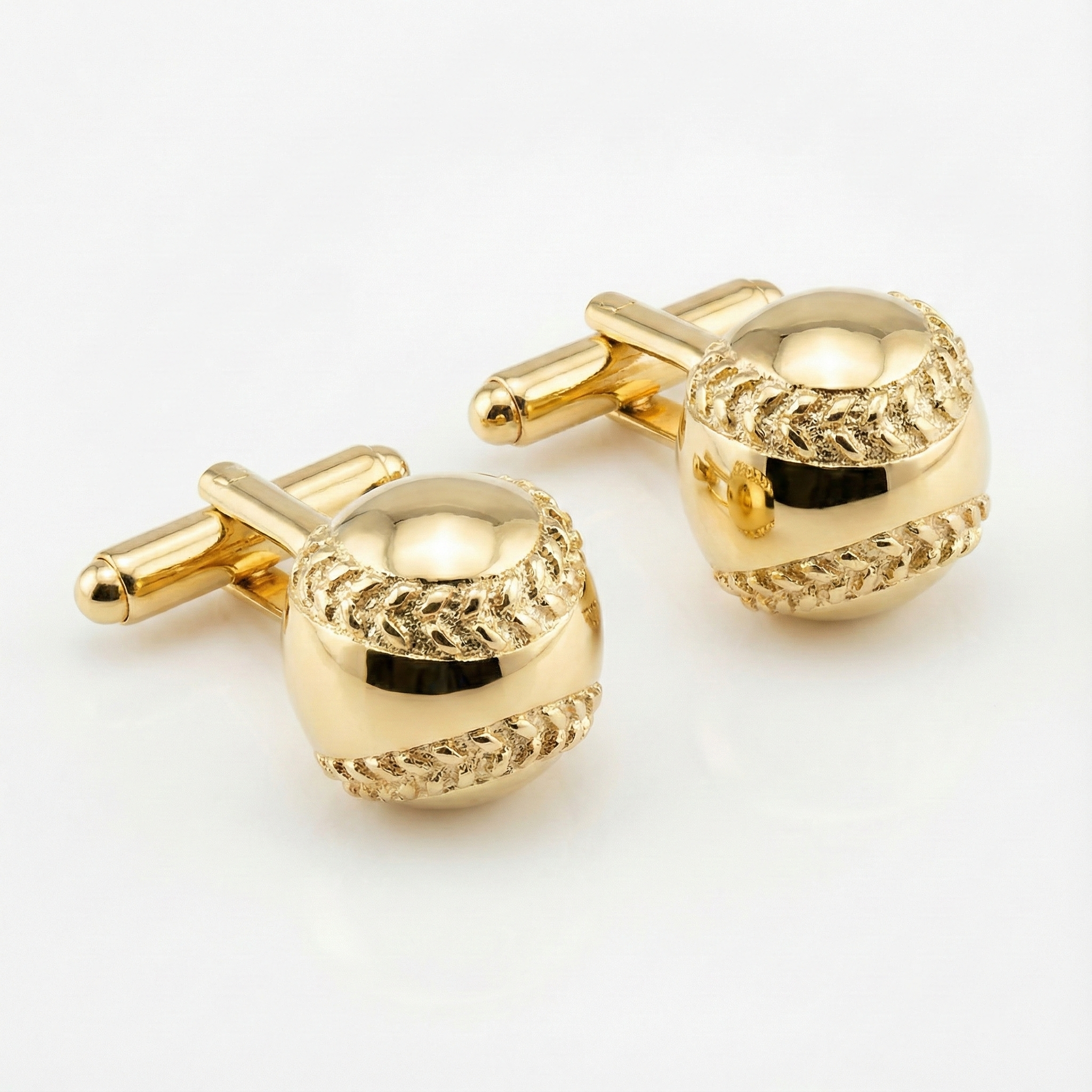 gold baseball cufflinks on white background