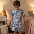 Child wearing a baseball-themed pajama set in a bedroom.