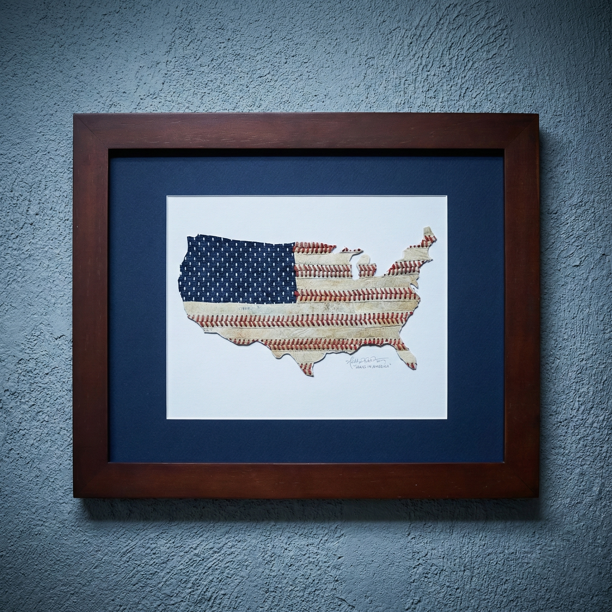 Framed artwork of a map of the United States with baseball seams American flag pattern on a blue wall.