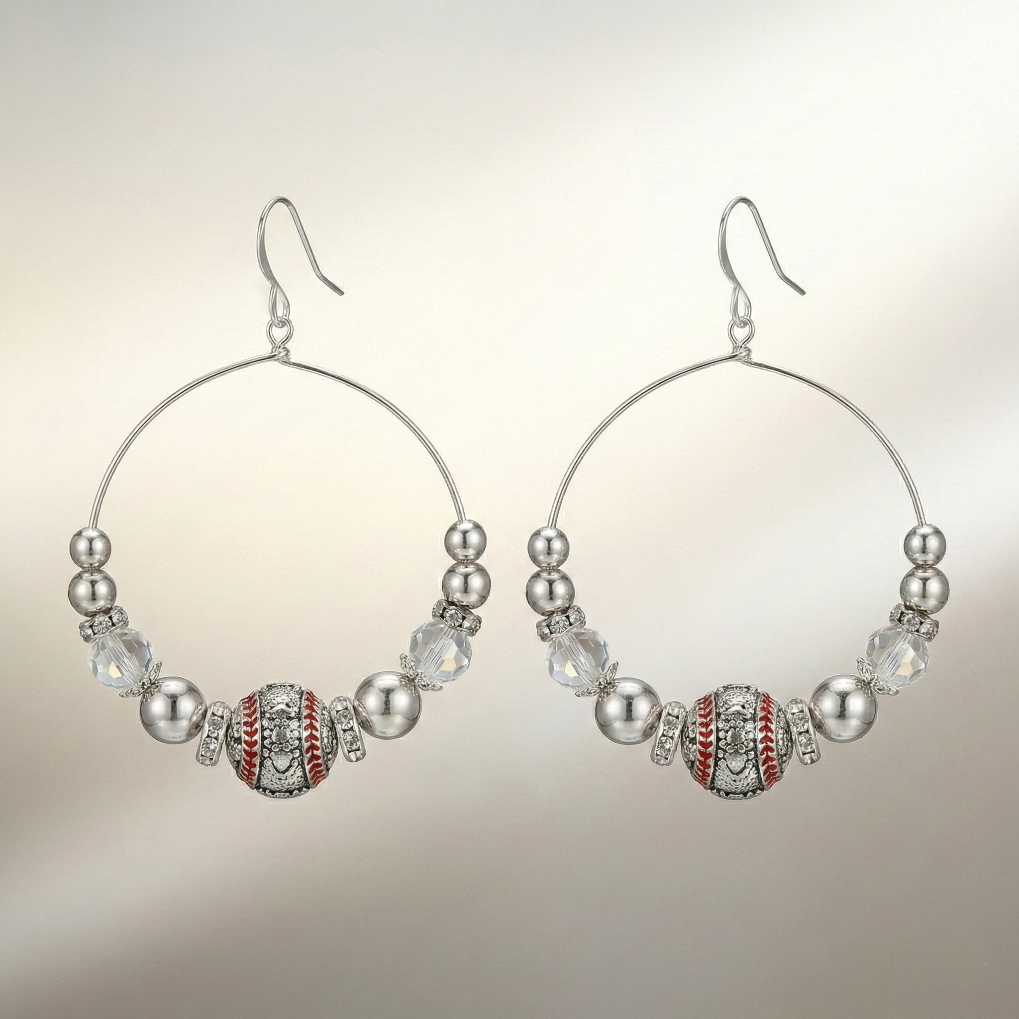 Hoop earrings with bead and baseball design on a neutral background
