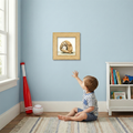 Child reaching towards a framed baseball glove picture on a blue wall with a bookshelf and sports equipment in the background.
