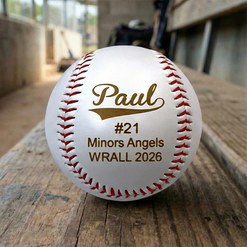Baseball with personalized text on a wooden surface, likely in a sports setting.