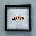 Framed baseball field base with 'Giants' logo on a gray wall