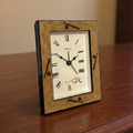 Wooden baseball alarm clock with white face and black Roman numerals on a wooden surface