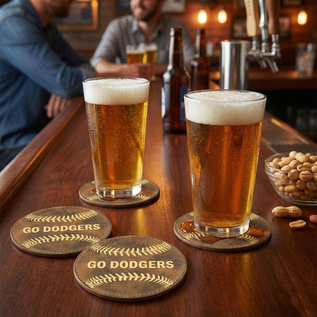 Two glasses of beer on a bar with 'GO DODGERS' baseball coasters.