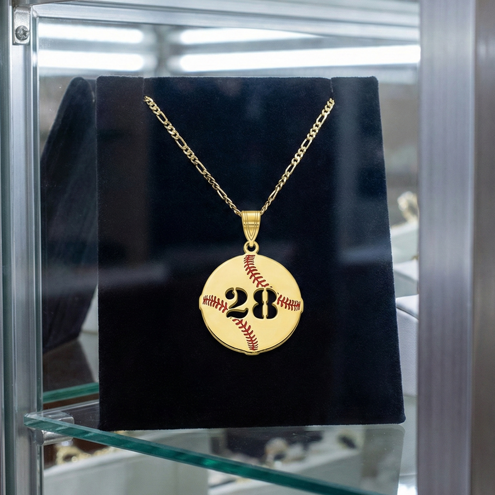 Gold necklace with a custom baseball number pendant displaying the number 28 on a black stand.