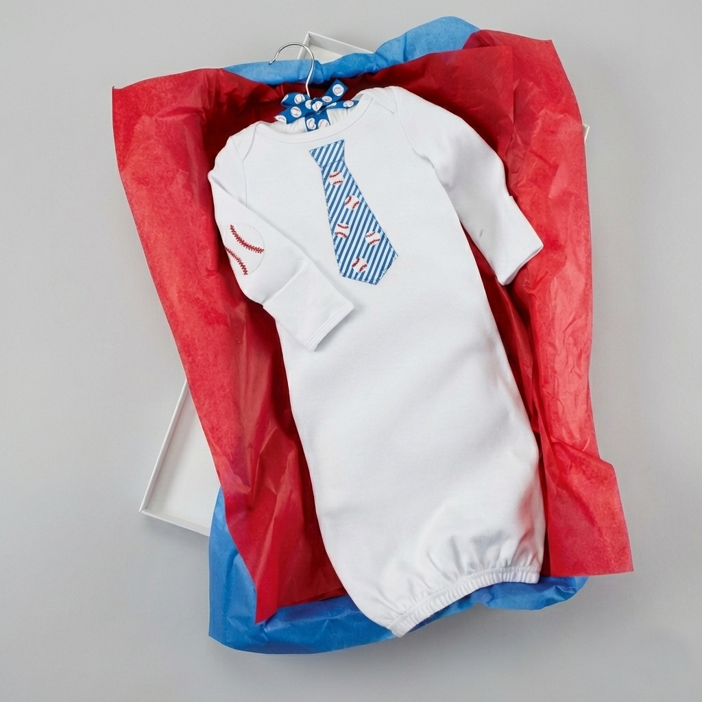 White baseball baby sleep gown onesie outfit with blue and red tissue on a gray background