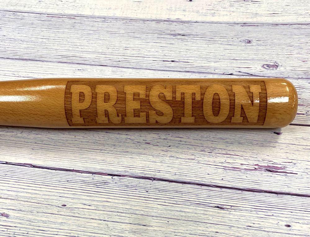 Wooden baseball bat gift with 'PRESTON' engraving on a wooden surface