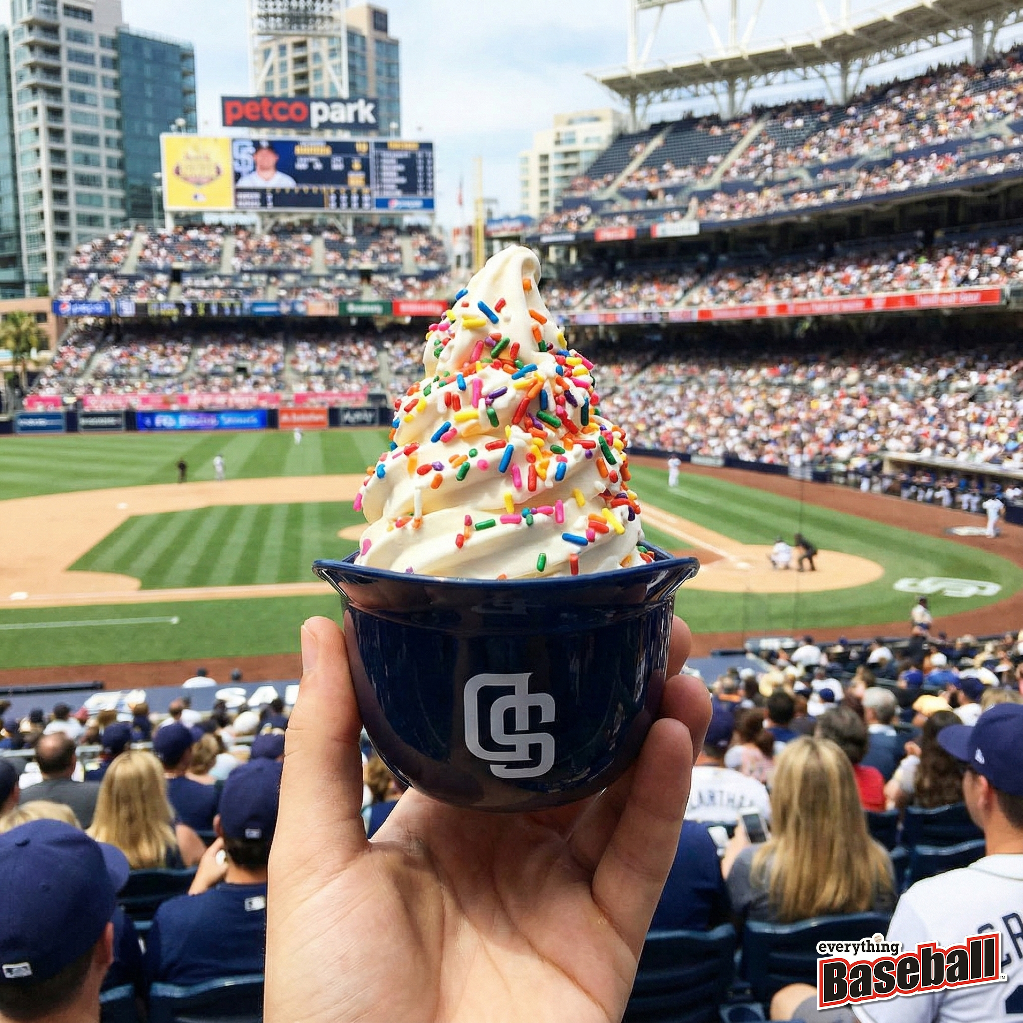 Ice cream sundae in Padres ice cream helmet with colorful sprinkles held up at a baseball game in Petco Park