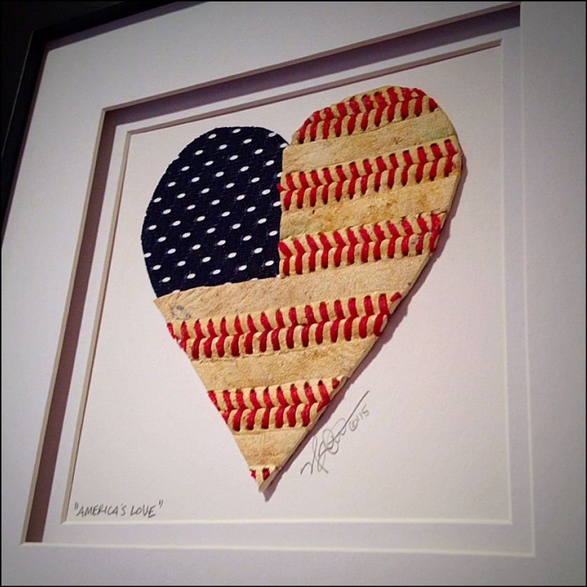 Heart-shaped American flag artwork made from baseballs with American flag design, framed on a white background.