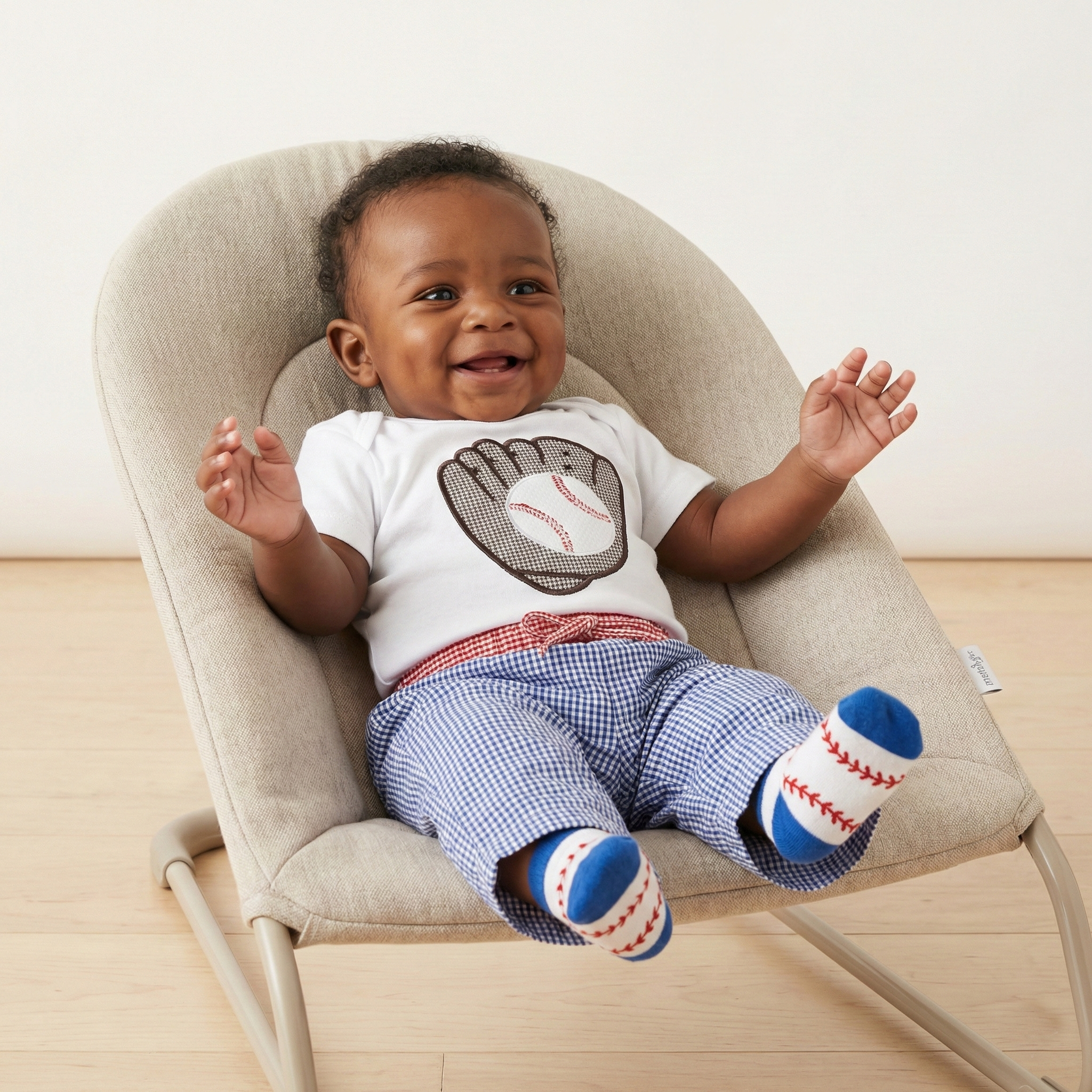 cute baby wearing Mud Pie baseball outfit in a bouncy seat 