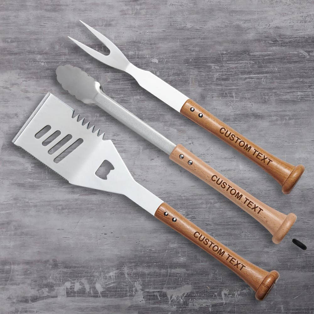 Three Baseball BBQ utensils with wooden handles on a gray surface