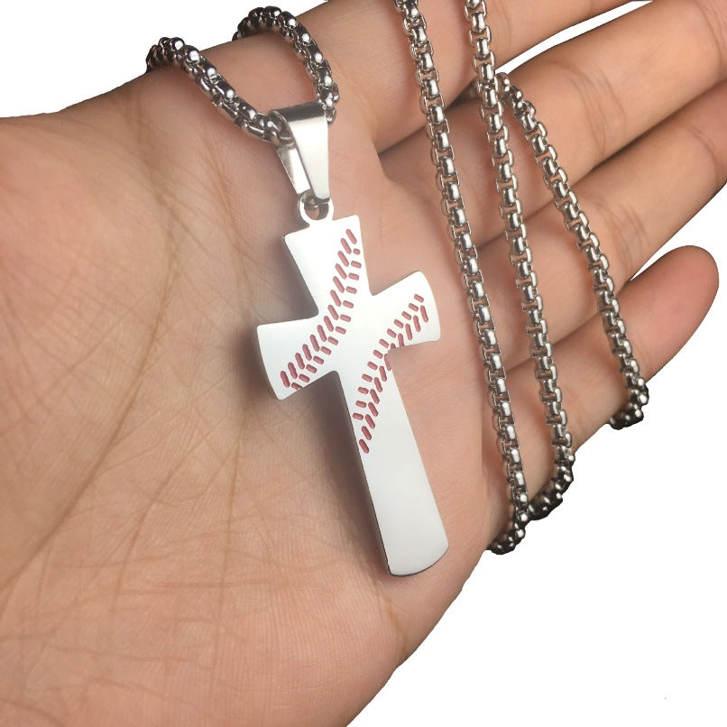 Silver cross pendant with baseball design on a chain held in a hand.