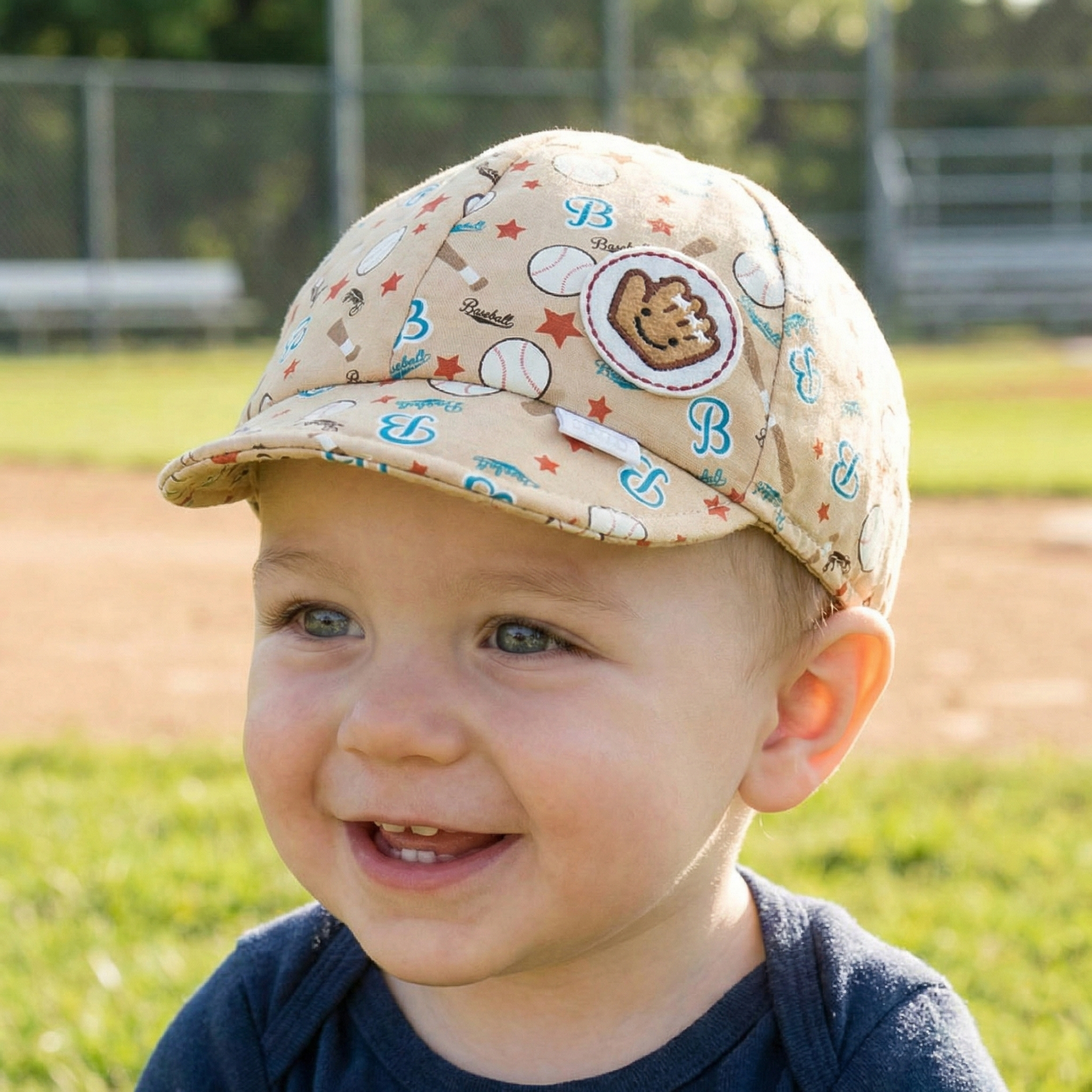 Beige baseball baby cap on a baby at the baseball field
