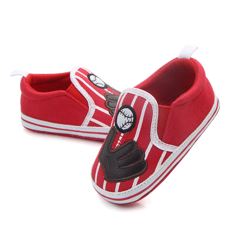 Red and white baby baseball shoes with black accents on a white background
