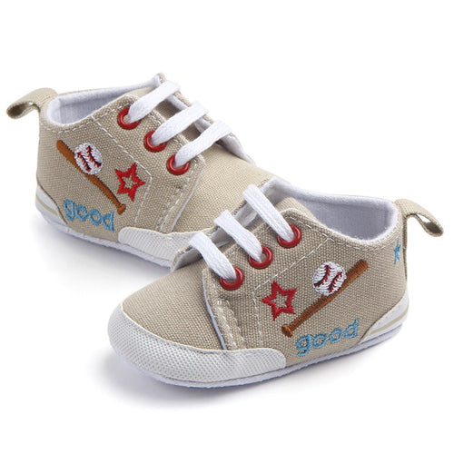 Beige baseball baby sneakers with white laces and decorative elements on a white background