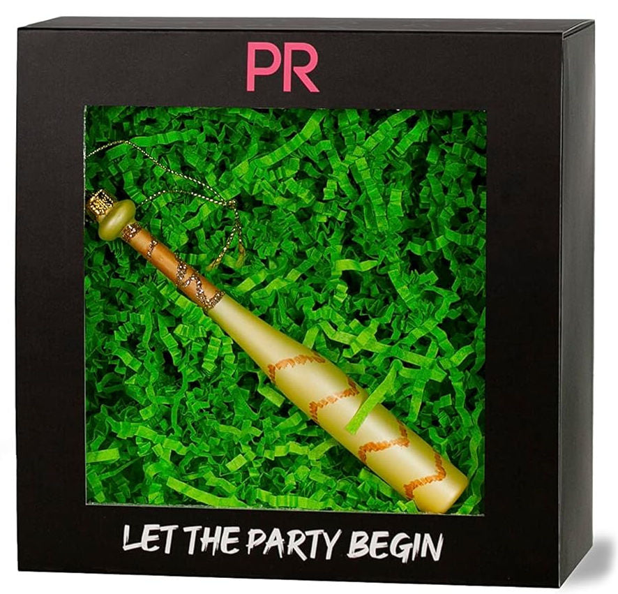 Decorative baseball bat glass ornament with 'PR' logo and 'Let the Party Begin' text on a black box with green grass-like interior.