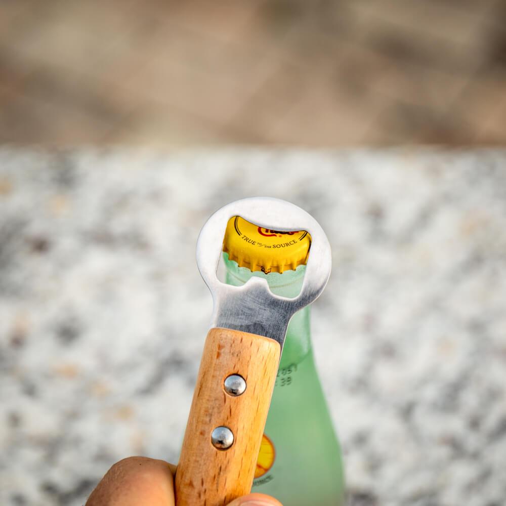 Baseball bat bottle opener with wooden handle opening a bottle