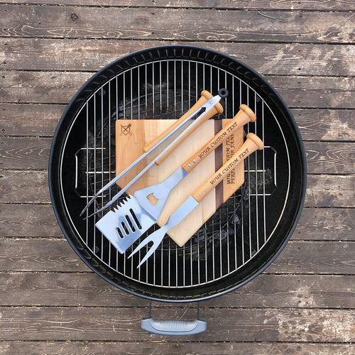 Barbecue grill with baseball bbq utensils on a wooden surface