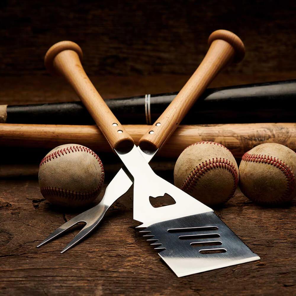 Barbecue utensils with baseballs and bats on a wooden surface