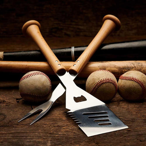 Barbecue utensils with baseballs and bats on a wooden surface