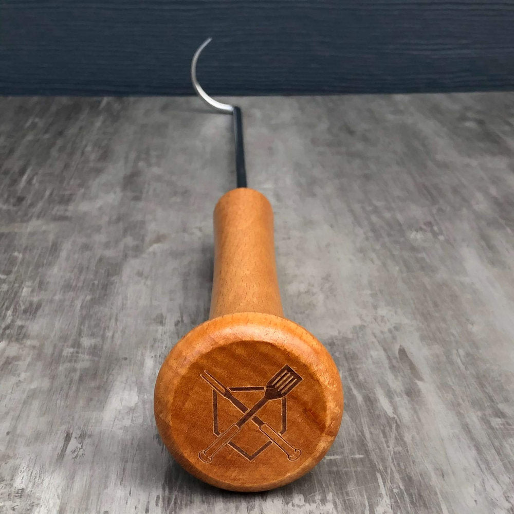 Wooden baseball bat handle with metal grill pigtail hook on a gray surface