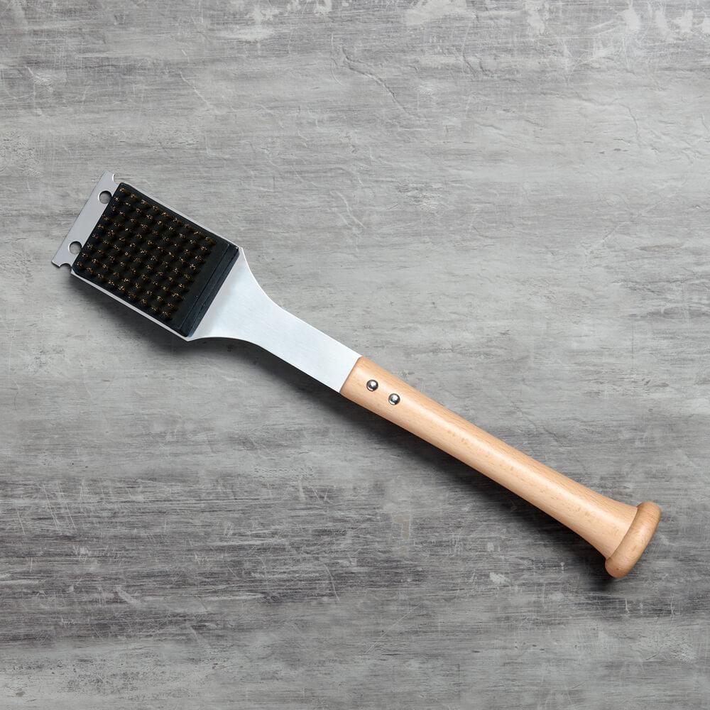 Barbecue bbq grill brush with bristle head and wooden baseball bat handle on a gray surface