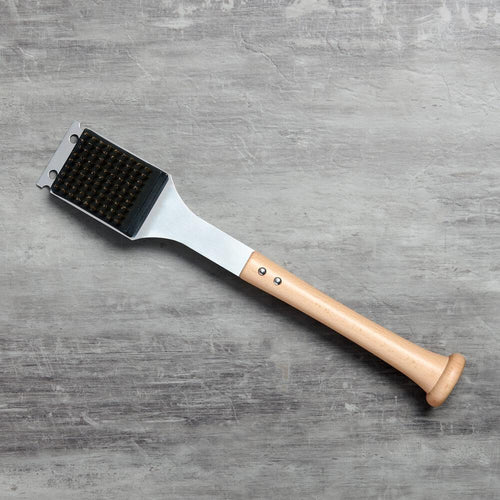 Barbecue bbq grill brush with bristle head and wooden baseball bat handle on a gray surface