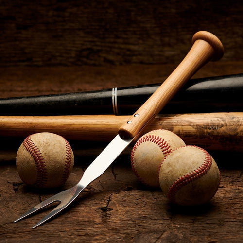 Baseball bat, baseballs, and a grill fork on a wooden surface with a dark background