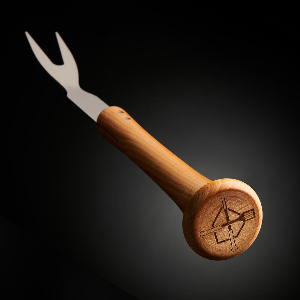 Wooden-handled bbq grill fork with baseball bat handle on a dark background