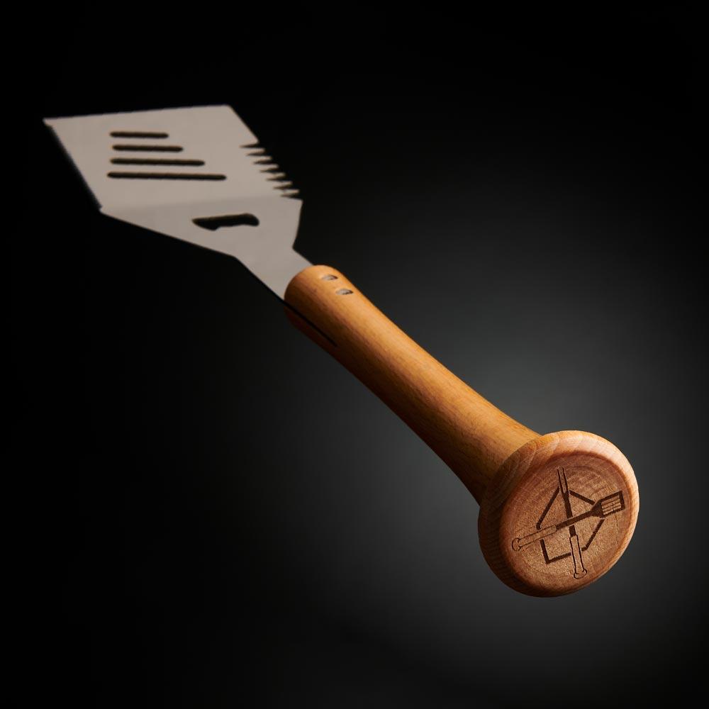 BBQ grill spatula with wooden baseball bat handle on a dark background