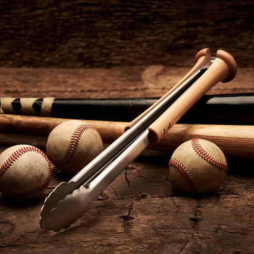 Grill tongs with baseballs and bats on a wooden surface