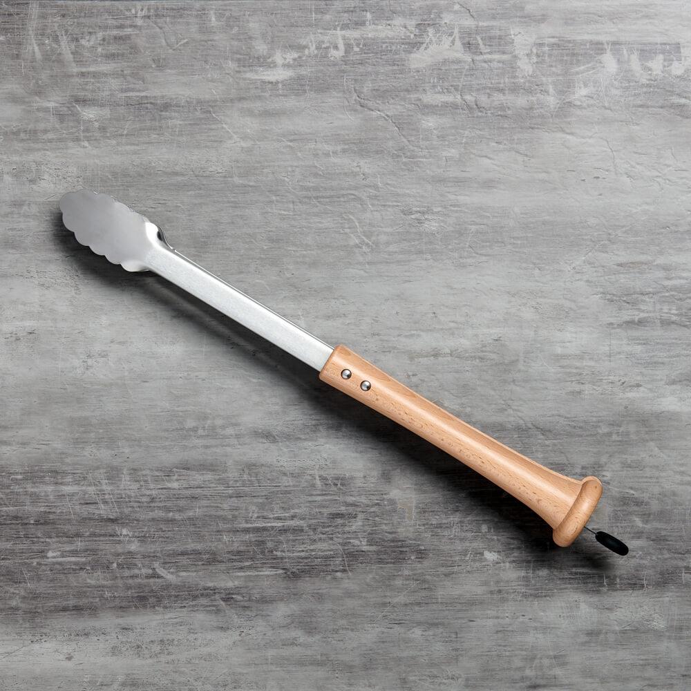 Grill tongs with wooden baseball bat handle on a gray textured surface