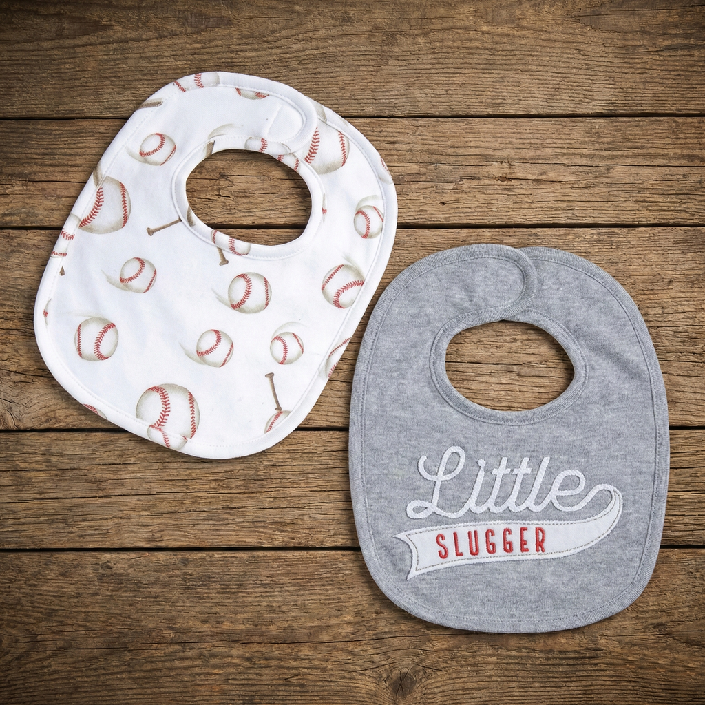 Mud Pie Little Slugger Baseball Bib Set on a wood floor