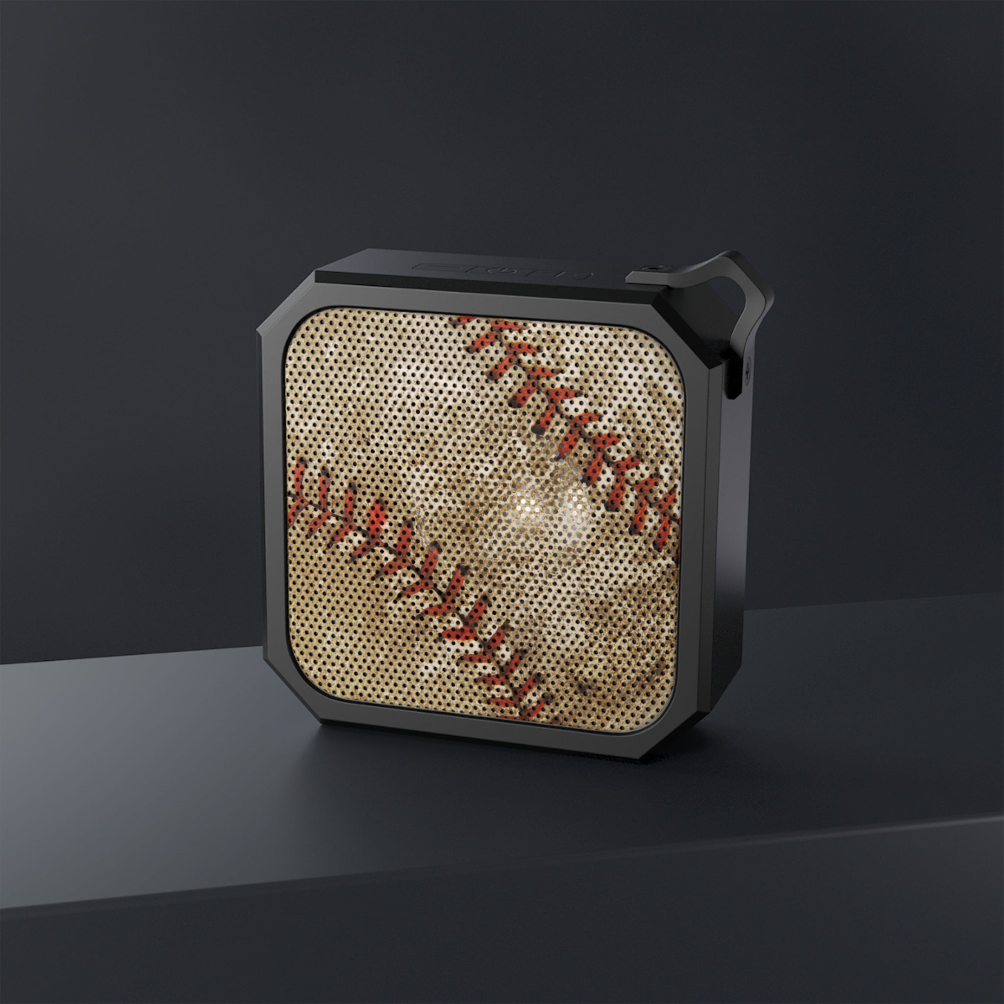 Black portable speaker with honeycomb pattern on a dark background