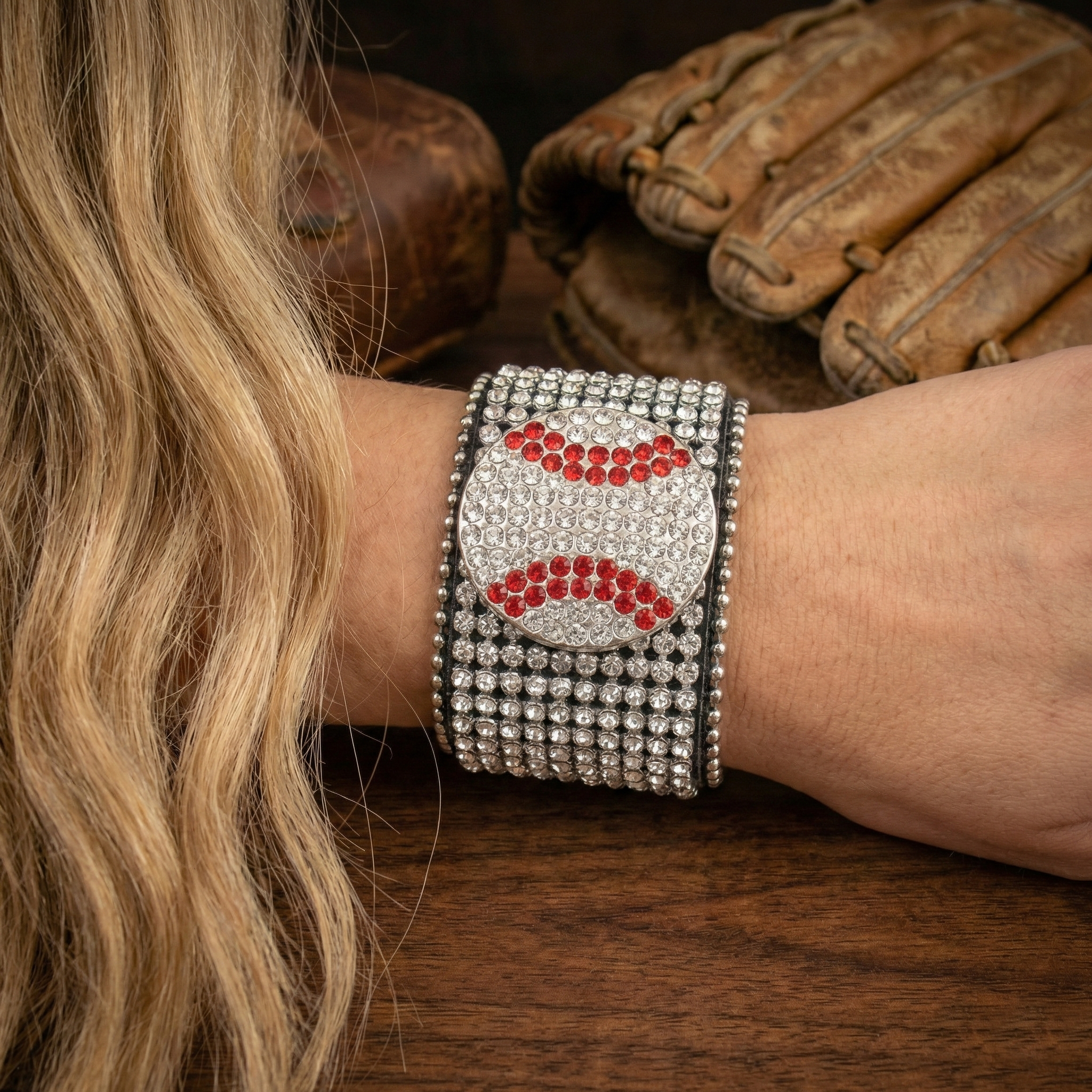 Baseball Crystal Cuff Bracelet on a woman's wrist near baseball equipment