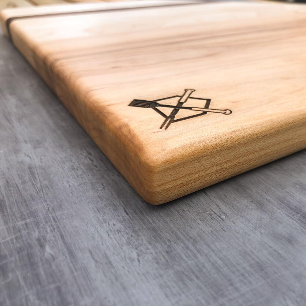 Wooden baseball bbq cutting board with engraved design on a gray surface