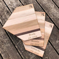 Set of wooden cutting boards with engraved names on a wooden surface