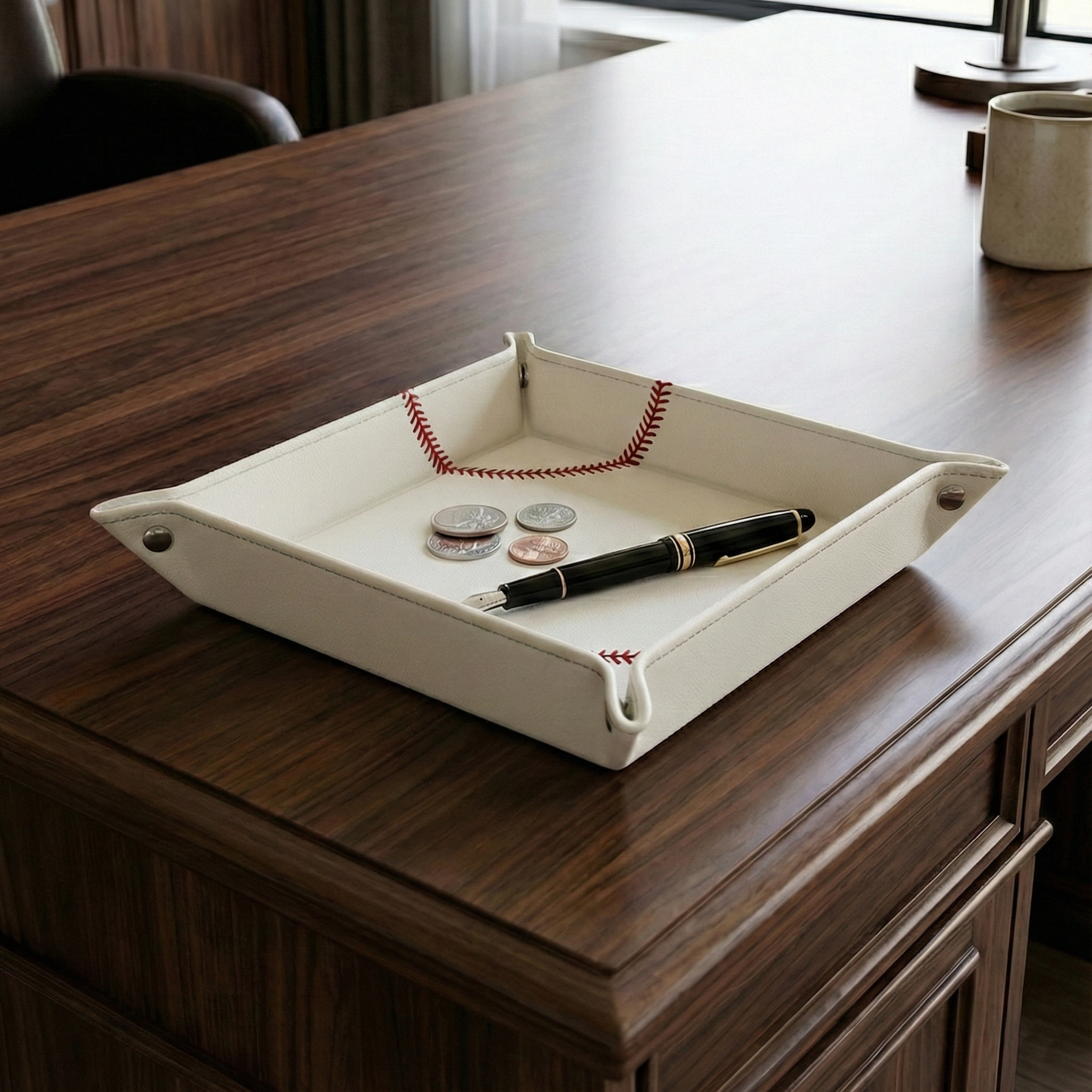 White Baseball Desk Caddy on a wooden desk with coins and pen.