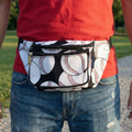 Person wearing a fanny pack with baseball pattern outdoors