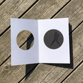 Open greeting card with moving batter and opening on the front on a wooden surface